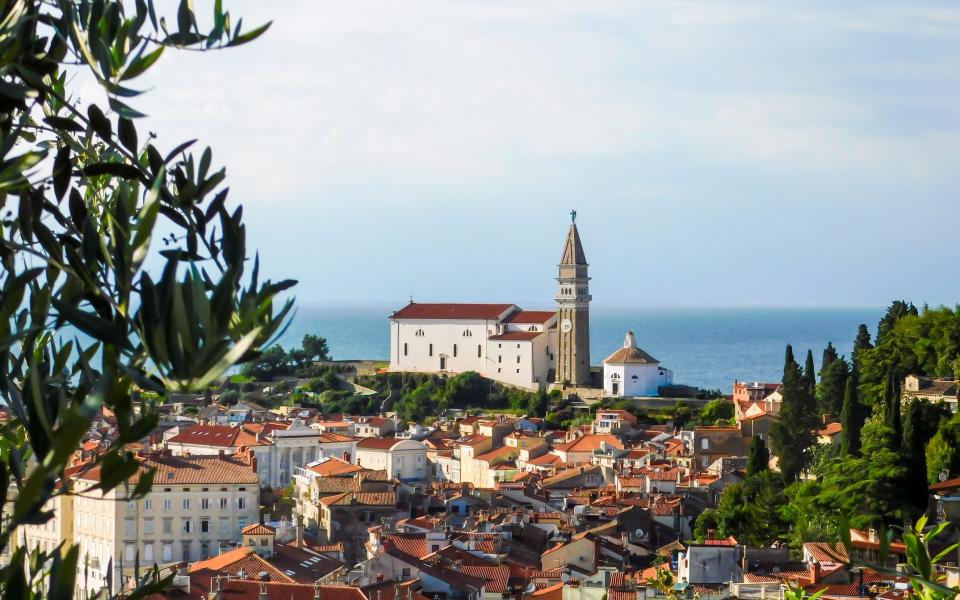 rooftops overlooking sea with church in prominent view - Getty Images/EyeEm