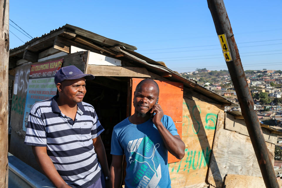 Image: Richard Ncube, left, and Dawood Phillip had devices and parts stolen from their cellphone repair shop during widespread unrest in Durban, South Africa last week. (Linda Givetash / NBC news)