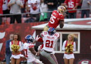 SAN FRANCISCO, CA - NOVEMBER 13: Vernon Davis #85 of the San Francisco 49ers jumps over Kenny Phillips #21 and Michael Coe #37 of the New York Giants for a touchdown at Candlestick Park on November 13, 2011 in San Francisco, California. (Photo by Ezra Shaw/Getty Images)