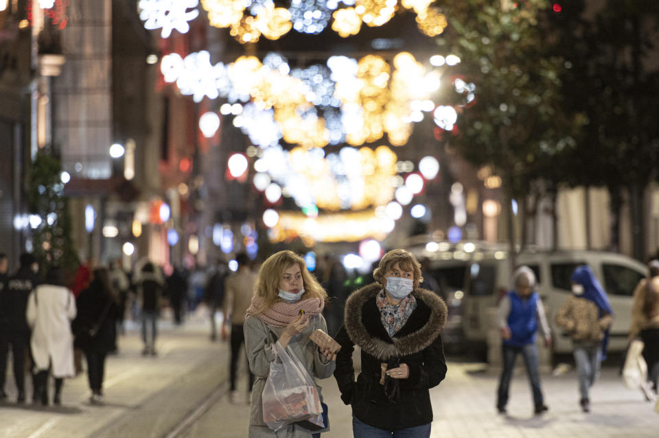 People, wearing masks to help curb the spread of the coronavirus, walk in Istiklal street, the main shopping street in Istanbul, late Wednesday, Nov. 25, 2020. The number of daily COVID-19 infections in Turkey jumped to above 28,000 on Wednesday after, in a surprise development, the government resumed publishing all positive cases and not just the number of patients being treated for symptoms of the coronavirus.The government was accused of hiding the full extent of the virus spread in Turkey, after it was revealed that the number of asymptomatic cases were not being included in data published since July 29. (AP Photo)