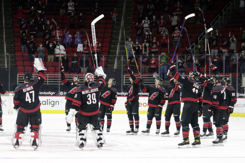 The Carolina Hurricanes salute the fans, who returned to PNC Arena for the first time this season, after a win over the Detroit Red Wings in an NHL hockey game in Raleigh, N.C., Thursday, March 4, 2021. AP Photo/Chris Seward)