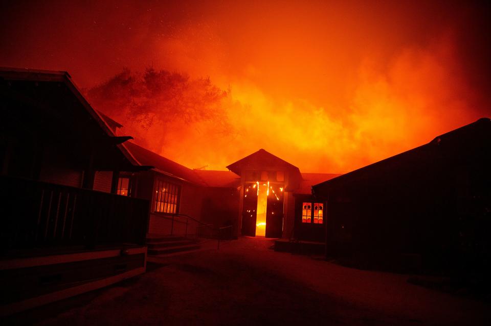 The doors to the Soda Rock Winery burst open as it burns in Healdsburg, California on October 27, 2019. - Powerful winds were fanning wildfires in northern California in "potentially historic fire" conditions, authorities said October 27, as tens of thousands of people were ordered to evacuate and sweeping power cuts began in the US state. (Photo by Josh Edelson / AFP) (Photo by JOSH EDELSON/AFP via Getty Images)