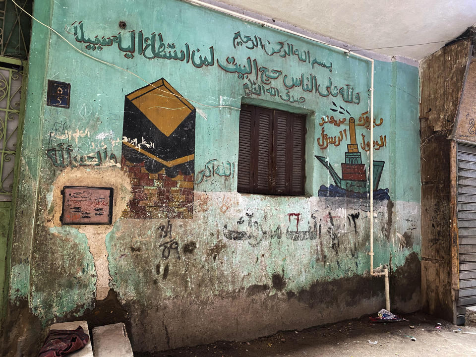 This April 17, 2020 photo, shows drawings on a wall of a home near a street where 73-year-old Ghaliya Abdel-Wahab died from COVID-19 on April 6, 2020, on one of two streets on complete lockdown closed off by security forces for people to quarantine after her death, in Bahtim, Shubra el-Kheima neighborhood, Qalyoubiya governorate, Egypt. (AP Photo/Nariman El-Mofty)
