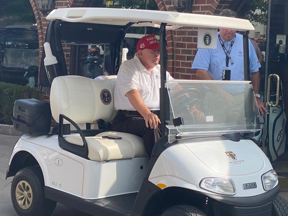 Former President Trump sits in his golf cart before heading to the driving range.