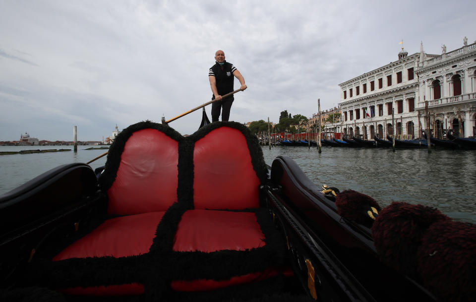 In this picture taken on Wednesday, May 13, 2020, gondoliers President Andrea Balbi sails his gondola at the canal Grande (Grand Canal) in Venice, Italy. Venetians are rethinking their city in the quiet brought by the coronavirus pandemic. For years, the unbridled success of Venice's tourism industry threatened to ruin the things that made it an attractive destination to begin with. Now the pandemic has ground to a halt Italy’s most-visited city, stopped the flow of 3 billion euros in annual tourism-related revenue and devastated the city's economy. (AP Photo/Antonio Calanni)