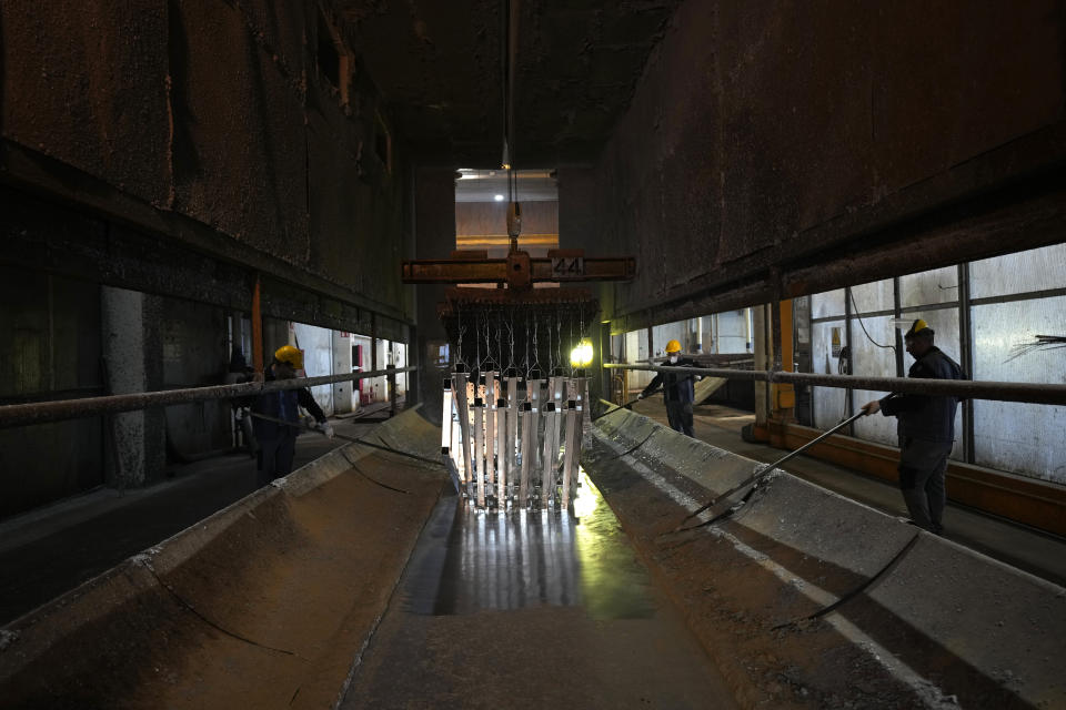 Men work in a galvanizing plant in Cambiano, northern Italy, Friday, Sept. 16, 2022. Zinc baths at Giambarini Group's galvanizing plants in northern Italy must remain super-heated around the clock, seven days a week, an energy-intensive process that has grown exponentially more costly as gas prices spike. The energy crisis facing Italian industry and households is a top voter concern going into Sunday's parliamentary elections as fears grow that astronomically high bills will shutter some businesses and force household rationing by winter. (AP Photo/Antonio Calanni)