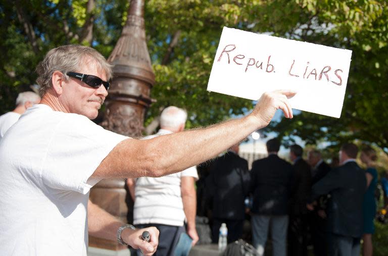 Protester Scott Osberg holds a placard calling republicans liars during a press conference on Capitol Hill in Washington, DC, September 30, 2013