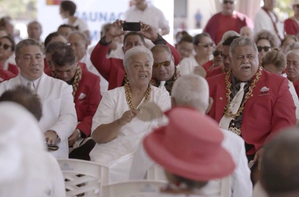 In this image made from video, Prime Minister-elect Fiame Naomi Mata’afa, center with fan, dits with her supporters Monday, May 24, 2021, in Apia, Samoa. Samoa was plunged into a constitutional crisis Monday when Mata’afa, who won an election last month, was locked out of Parliament and the previous leader claimed he remained in charge. (Australian Broadcasting Corporation via AP)