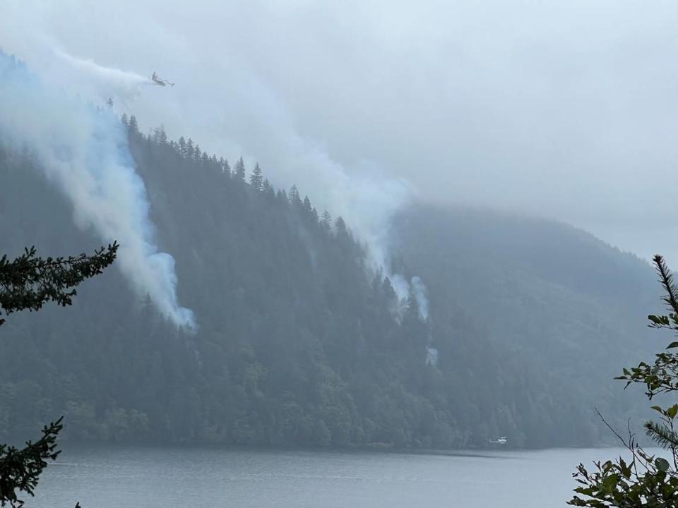 A tanker aircraft drops water on the Blue Canyon Fire as seen from the High Bridge on Tuesday across Lake Whatcom.