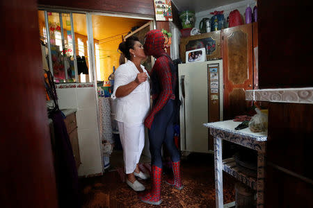 Moises Vazquez, 26, known as Spider-Moy, a computer science teaching assistant at the Faculty of Science of the National Autonomous University of Mexico (UNAM), who teaches dressed as a comic superhero Spider-Man, kisses his mother before leaving home in Iztapalapa neighbourhood, in Mexico City, Mexico, May 27, 2016. REUTERS/Edgard Garrido