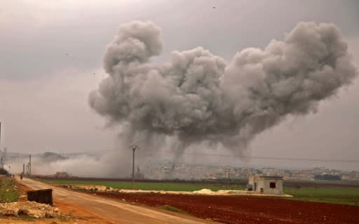 A large plume of smoke billows into the air above the rebel-held town of Atareb as government forces keep up their bombardment