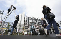 TV crews and photographers and cameramen set up their ladders in front of Tokyo Detention Center, where former Nissan Chairman Carlos Ghosn is detained, Thursday, April 25, 2019, in Tokyo. Detained former Nissan chairman Ghosn paid 500 million yen ($4.5 million) in bail, the Tokyo District court said Thursday, signaling he would likely soon be released. (AP Photo/Eugene Hoshiko)