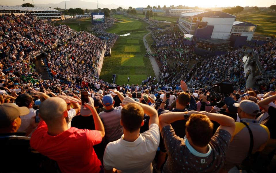 Fans shield their eyes as McIlroy drives on the first tee (Getty Images)