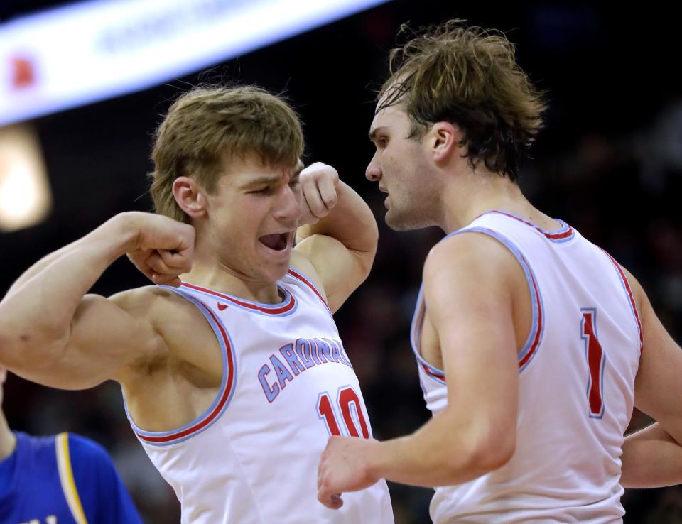 Newman Catholic's Conner Krach, left, and Mason Prey celebrate near the end of their team’s victory over McDonell Central Catholic during the WIAA Division 5 state championship boys basketball game Saturday at the Kohl Center in Madison.