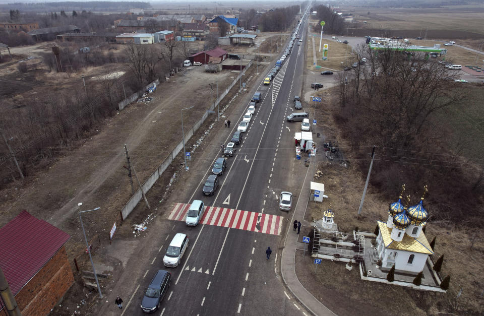 People fleeing from the conflict drive cars heading to the Ukrainian and Romania border near Cernivtsi, in Ukraine, Tuesday, March 1, 2022. Russia on Tuesday stepped up shelling of Kharkiv, Ukraine's second-largest city, pounding civilian targets there. Casualties mounted and reports emerged that more than 70 Ukrainian soldiers were killed after Russian artillery recently hit a military base in Okhtyrka, a city between Kharkiv and Kyiv, the capital. (IHA Photo via AP)