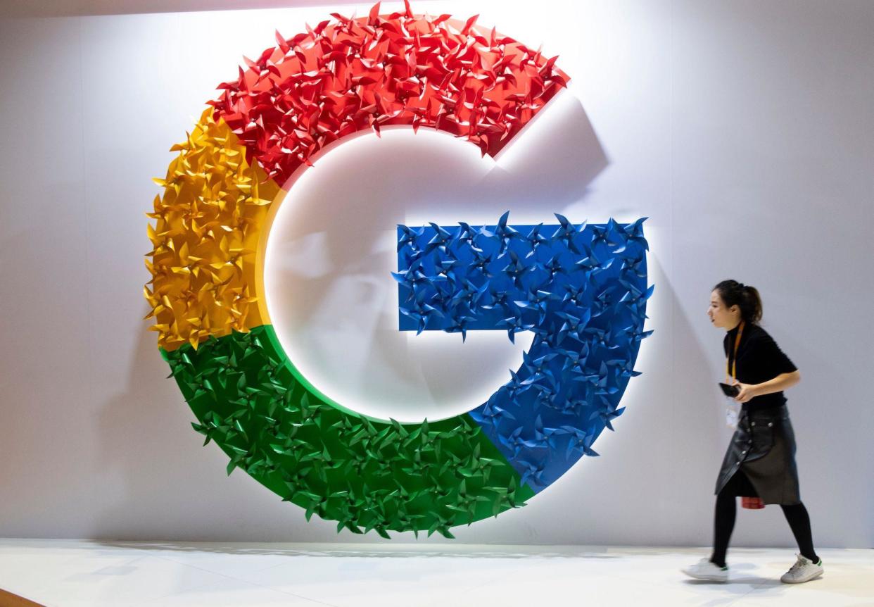 This picture taken on November 5, 2018 shows a woman passing a booth of Google at the first China International Import Expo (CIIE) in Shanghai: JOHANNES EISELE/AFP/Getty Images