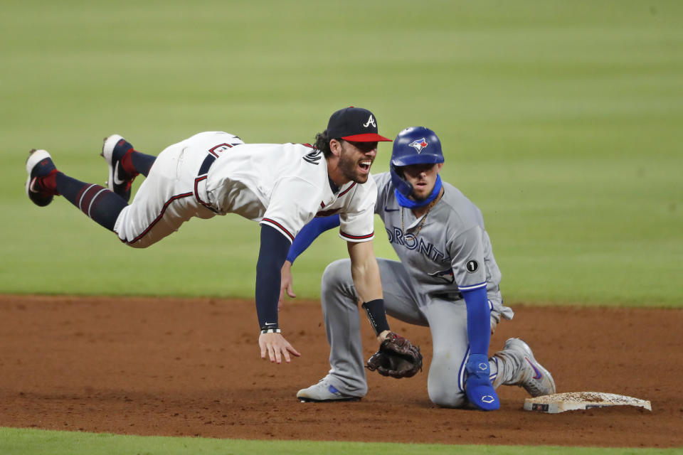 Atlanta Braves shortstop Dansby Swanson (7) avoids Toronto Blue Jays' Cavan Biggio (8) as he turns a double play on a Teoscar Hernandez ground ball in the sixth inning of a baseball game Tuesday, Aug. 4, 2020, in Atlanta. (AP Photo/John Bazemore)