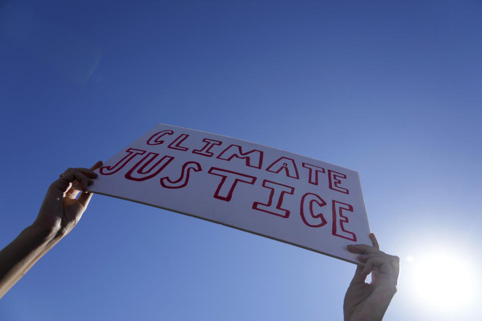 A demonstrator holds a sign reading "climate justice" at a Fridays for Future protest calling for money for climate action at the COP27 U.N. Climate Summit, Friday, Nov. 11, 2022, in Sharm el-Sheikh, Egypt. (AP Photo/Peter Dejong)