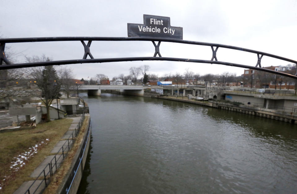 FILE - This Jan. 26, 2016 file photo shows a sign over the Flint River noting Flint, Mich., as Vehicle City. The U.S. Environmental Protection Agency says states are taking action to address the risk of lead in drinking water but more needs to be done to share key information with the public. (AP Photo/Carlos Osorio, File)