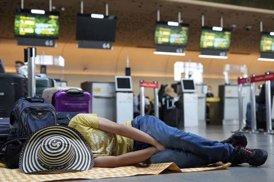 A Viva Air passenger sleeps at the airport after the low-cost airline suspended its operations at the El Dorado International Airport in Bogota, Colombia, Tuesday, Feb. 28, 2023. The airline is awaiting the completion of an integration process with a group of airlines that must be approved by the Colombian authorities. (AP Photo/Fernando Vergara)