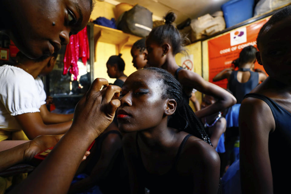 A young dancer has her makeup applied at Project Elimu social hall, prior to the start of a Christmas ballet event in Kibera, one of the busiest neighborhoods of Kenya's capital, Nairobi, Friday, Dec. 15, 2023. The ballet project is run by Project Elimu, a community-driven nonprofit that offers after-school arts education and a safe space to children in Kibera. (AP Photo/Brian Inganga)