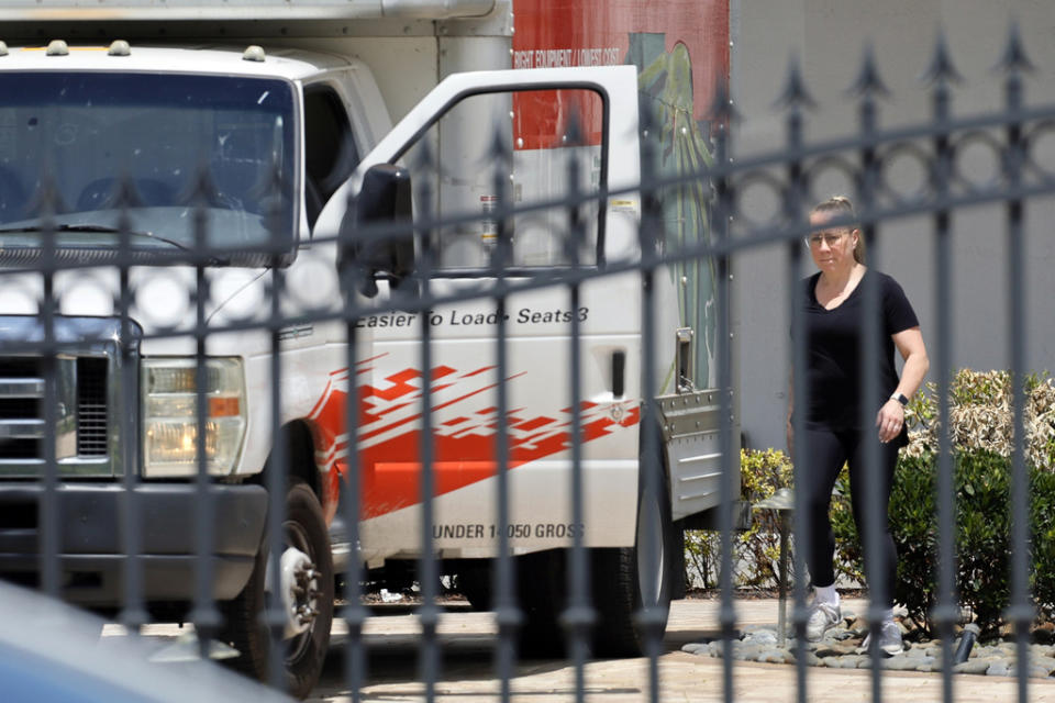 A woman leaves Sean Kingston’s home in Southwest Ranches, Fla., Thursday, May 23, 2024. A SWAT team raided rapper Kingston’s rented mansion on Thursday, and arrested his mother on fraud and theft charges that an attorney says stems partly from the installation of a massive TV at the home. Broward County detectives arrested Janice Turner, 61, at the home. (Amy Beth Bennett/South Florida Sun-Sentinel via AP)