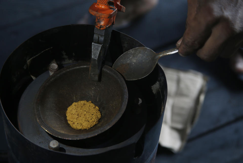 FILE - A miner processes gold he illegally extracted from the Madeira River in Nova Olinda, Amazonas state, Brazil, Nov. 26, 2021. One of Brazil’s biggest gold refiners, which has been accused of processing gold mined illegally deep in the Amazon rainforest, has been stripped of an important industry certification that global manufacturers from Apple to Tesla rely on to root out abuses in their supply chains. (AP Photo/Edmar Barros, File)