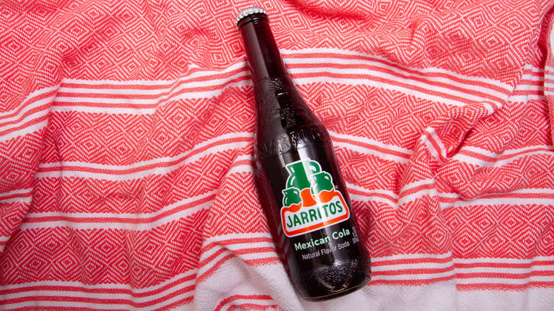 Cola Jarritos on beach towel