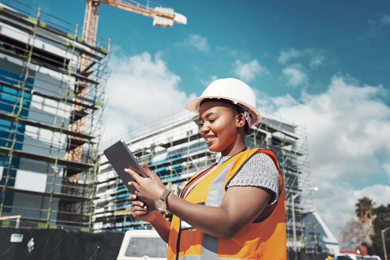 Shot of a young woman using a digital tablet while working at a construction site