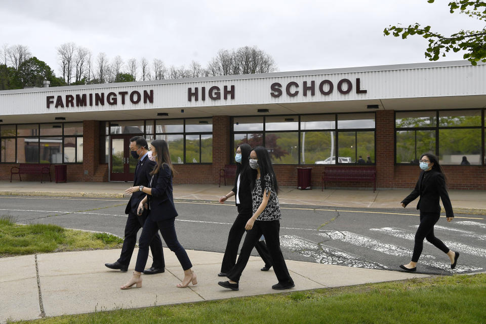 In this Monday, May 10, 2021 photo, Connecticut Attorney General William Tong left, walks with teacher Clarissa Tan, second from left, and students from the Asian American Student Union after speaking at a program for Asian Pacific American Heritage Month at Farmington High School in Farmington, Conn. The year of anti-Asian violence has led students and teachers to advocate for reexamining how Asian American studies and history are taught in public schools. (AP Photo/Jessica Hill)