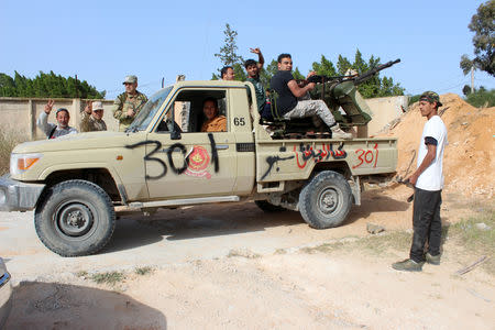 Members of the Libyan internationally recognised government forces gather around by an armed Toyota Land Cruiser, waving victory signs, at Khallat Farjan area in Tripoli, Libya April 20, 2019. REUTERS/Ayman al-Sahili
