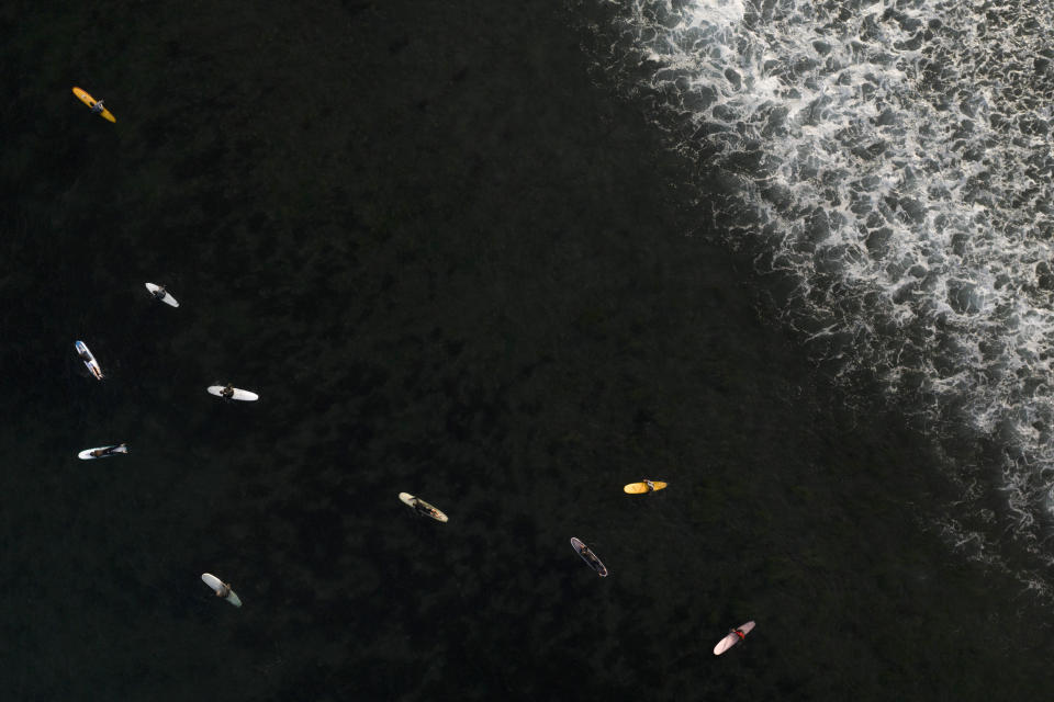 Surfers float in the water while waiting for a wave in Malibu, Calif., on Aug. 31, 2023. (AP Photo/Jae C. Hong)