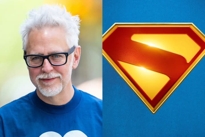 James Gunn smiles for a photo on the left with a Superman logo on the right.