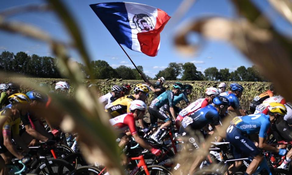 A man waves a French flag as the pack rides during the 11th stage between Chatelaillon Plage and Poitier.