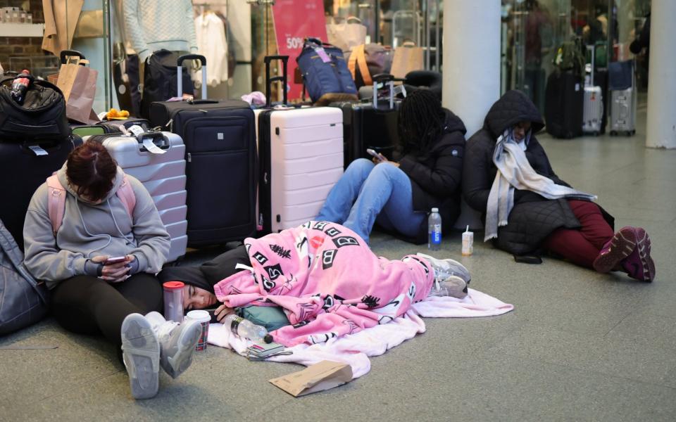 Passengers sit and wait for news after being stranded at St Pancras