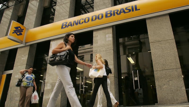 People walk by a Banco do Brasil bank in Rio de Janeiro, Friday, Jan. 9, 2009. A woman in Brazil wheeled a dead man into a bank and asked him to sign papers for a loan.