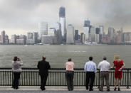 People watch the USS Donald Cook pass lower Manhattan and the World Trade Center site from Jersey City, N.J., Wednesday, May 23, 2012. Naval vessels ranging from a U.S. amphibious assault ship to a Finnish minelayer are participating in New York City's Fleet Week. (AP Photo/Seth Wenig)