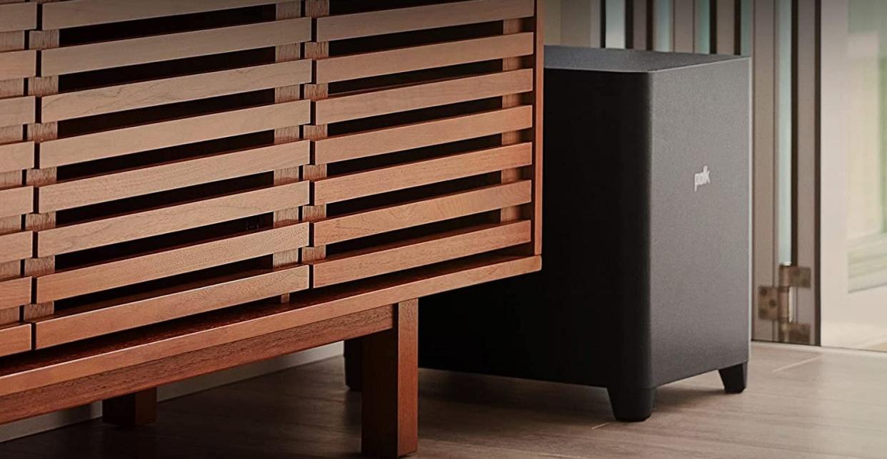 Polk's huge subwoofer placed next to a piece of furniture.