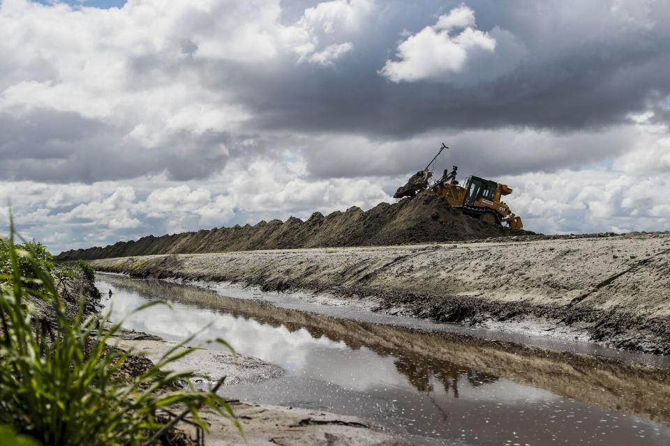 Crews raise a makeshift levee wall in an effort to contain the resurgent Tulare Lake.