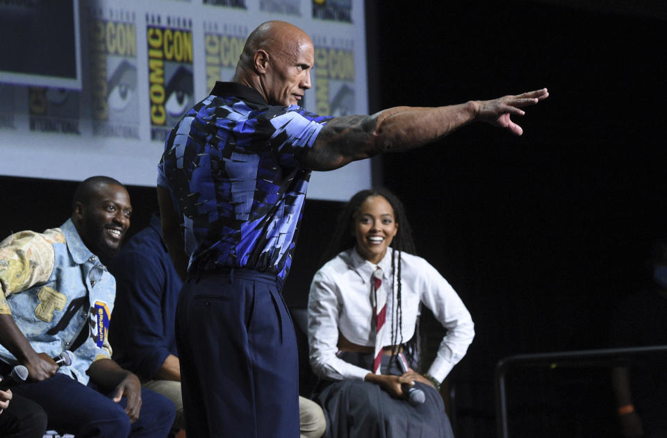 Aldis Hodge, from left, Dwayne Johnson, also known as The Rock, and Quintessa Swindell participate in the "Black Adam" portion of the Warner Bros. Theatrical panel on day three of Comic-Con International on Saturday, July 23, 2022, in San Diego. (Photo by Richard Shotwell/Invision/AP)
