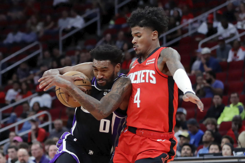 Sacramento Kings guard Malik Monk (0) drives into Houston Rockets guard Jalen Green (4) during the first half of an NBA basketball game Monday, Nov. 6, 2023, in Houston. (AP Photo/Michael Wyke)