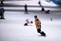 People snowboard inside an indoor ski park at Qiaobo Ice and Snow World in Shaoxing