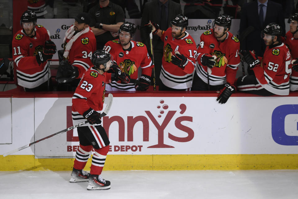 Chicago Blackhawks' Philipp Kurashev (23) celebrates with teammates at the bench after scoring a goal during the first period of an NHL hockey game against the Columbus Blue Jackets, Saturday, March 2, 2024, in Chicago. (AP Photo/Paul Beaty)