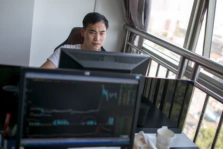 Zhang Xiongjie looks at a computer screen as he works at his office in Hangzhou, Zhejiang province, July 27, 2015. REUTERS/Chance Chan