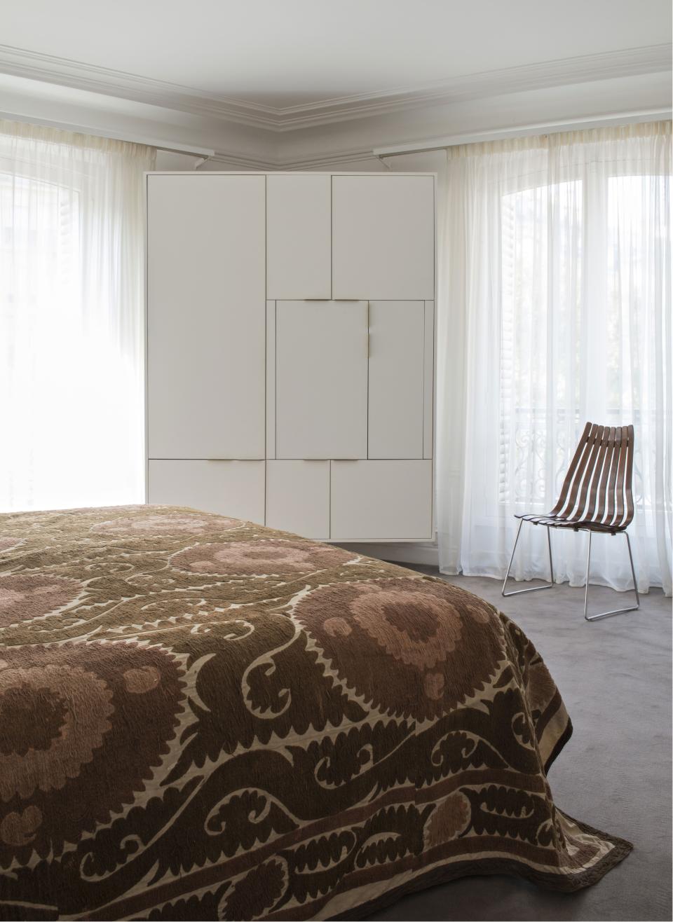 All of the bedrooms are lined up one after the other, with windows overlooking the street. Edmond Petit fabric and Codimat carpeting were once again used. On the bed is a Suzani spread while the rosewood chair was designed by Hans Brattrud. Dupuis created the closets and storage areas.