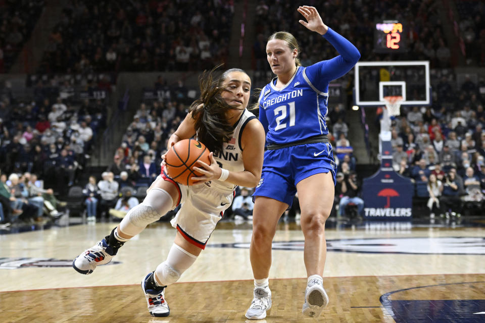 UConn's Nika Muhl drives to the basket as Creighton's Molly Mogensen (21) defends during the first half of an NCAA college basketball game Wednesday, Feb. 15, 2023, in Storrs, Conn. (AP Photo/Jessica Hill)