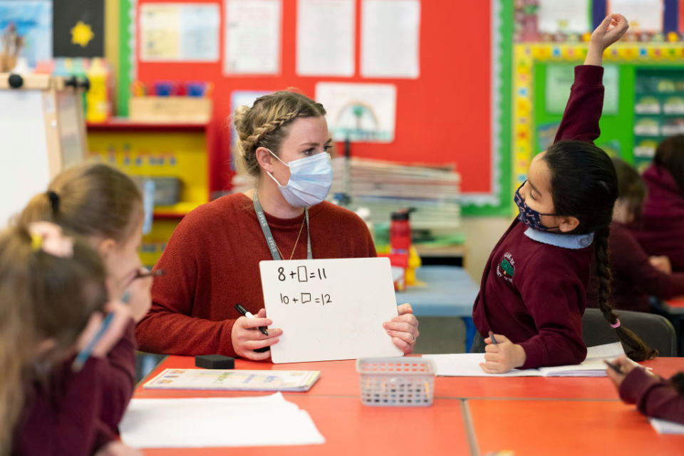 teacher at a table with students doing math