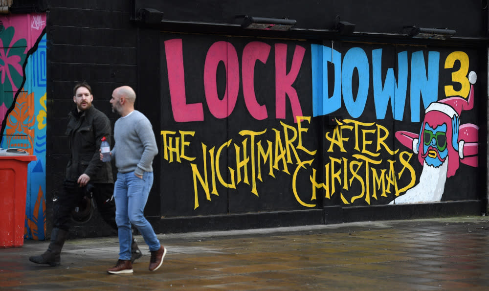 File picture shows pedestrians walking past graffiti reading ‘Lockdown 3: The Nightmare after Christmas’ painted on a boarded up restaurant in Manchester, England, February 15, 2021. — Reuters pic