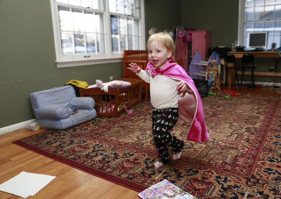 Felicity Beck-Kehoe runs wearing a cape through the family home of her parents Mike Beck and Joanne Kehoe as the family tries to combat cabin fever, Monday, Feb. 3, 2014, in Indianapolis. (AP Photo/R Brent Smith)