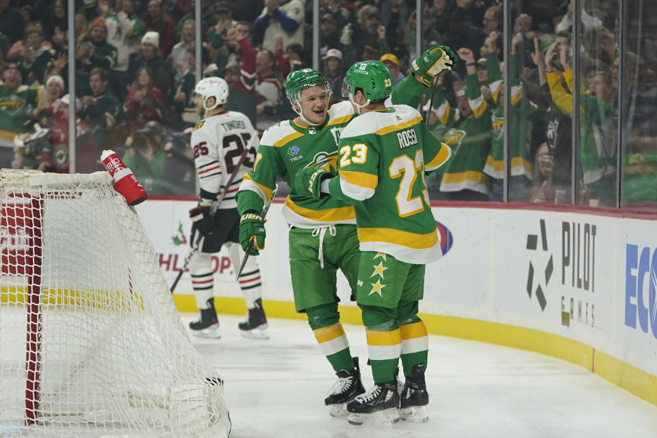 Minnesota Wild center Marco Rossi (23) celebrates with Minnesota Wild left wing Kirill Kaprizov, left, after scoring during the first period of an NHL hockey game against the Chicago Blackhawks, Sunday, Dec. 3, 2023, in St. Paul, Minn. (AP Photo/Abbie Parr)